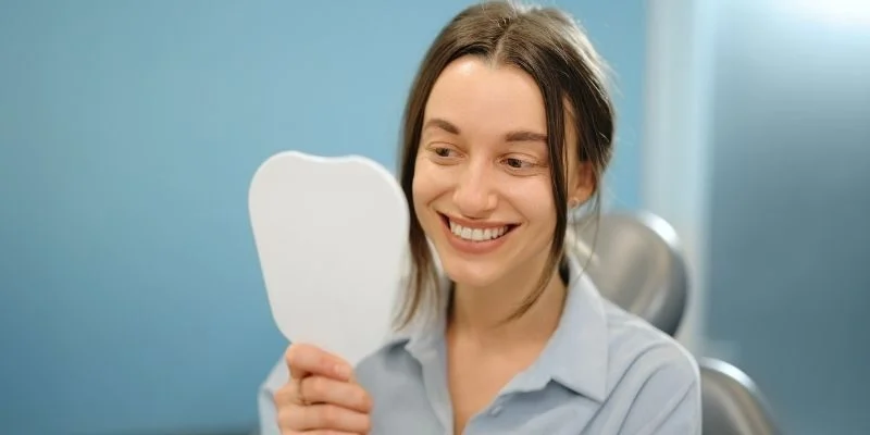 Woman smiling after full-arch dental implant treatment