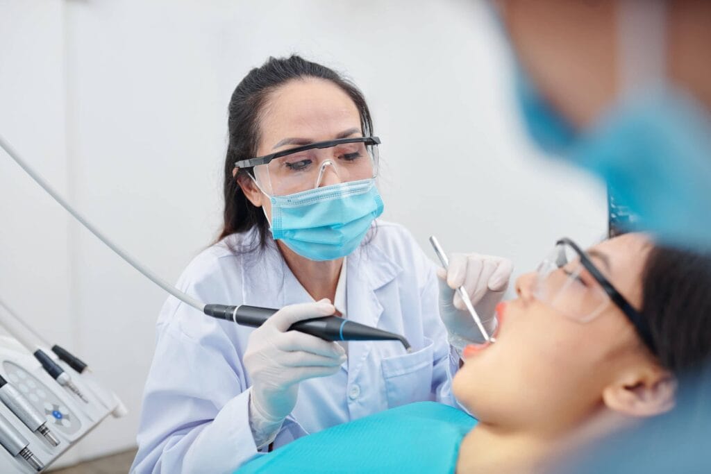 Dental professional examining a patient in a treatment chair