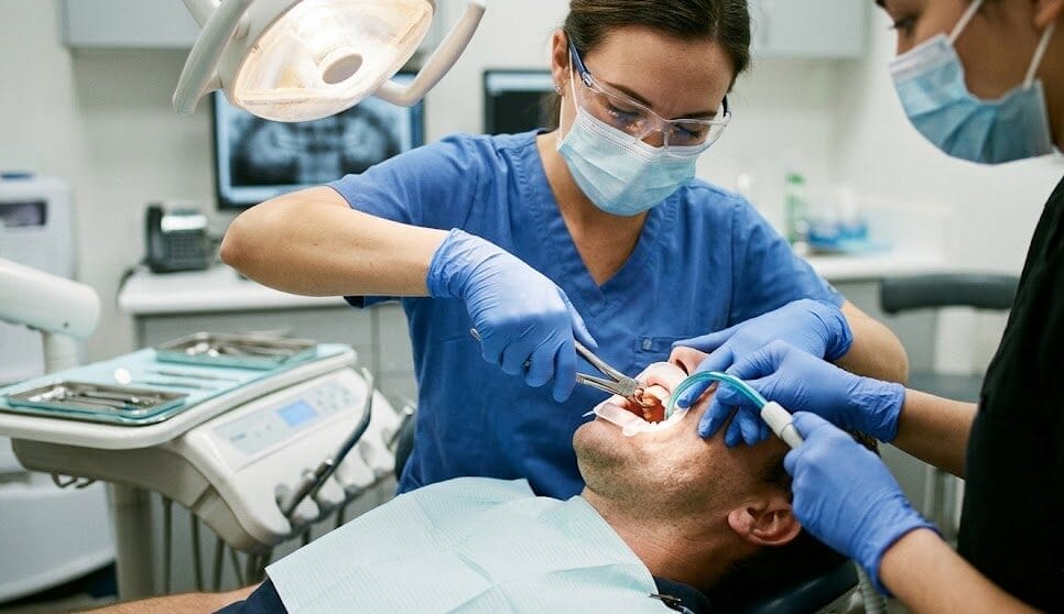 Dentist performing dental implant surgery to replace a missing tooth