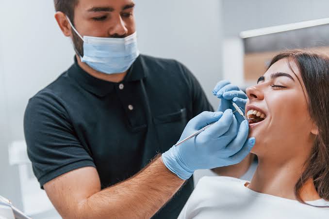 Dental professional checking a patient’s open mouth