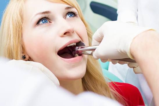 Dental professional examining a patient’s open mouth