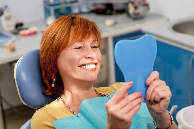 Woman smiling after All-on-X dental implant treatment
