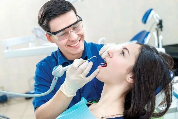 Dentist examining a patient’s teeth in a dental chair