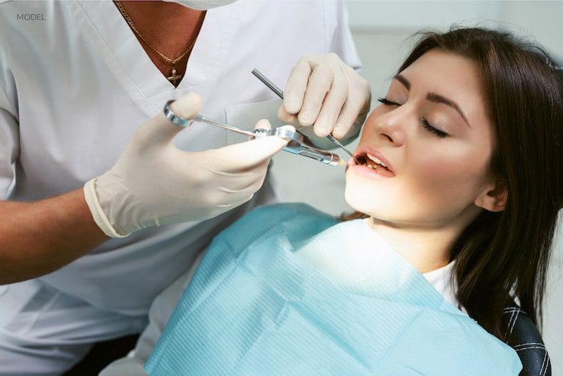 Dental professional examining a patient’s teeth